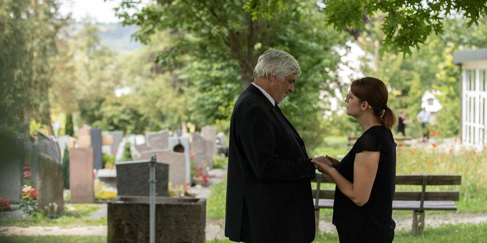 Trauernde auf dem Friedhof